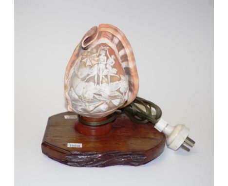 Carved cameo conch shell electric lamp with ornate figural and shell decoration, on a timber base, height 18cm approx.