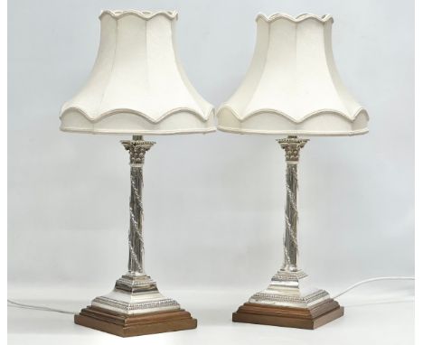 Sterling silver table lamps. A pair of 19th Century silver table lamps, converted from candlesticks. Raised on wooden bases a