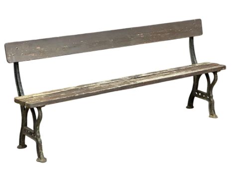 A Late Victorian cast iron garden bench with wooden straps. 183cm.