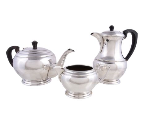  An Art Deco silver three piece tea service,   maker's mark obscured, Birmingham 1921, the bullet shaped tea pot with a wood 