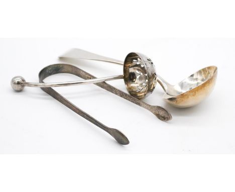 A collection of silver cutlery. Including a pair of foliate engraved Georgian sugar tongs, a sugar sifting spoon and sauce la