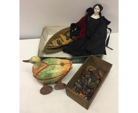 A box of misc toys to include a quantity of lead cowboy figures and a dressed doll with ceramic head & feet.