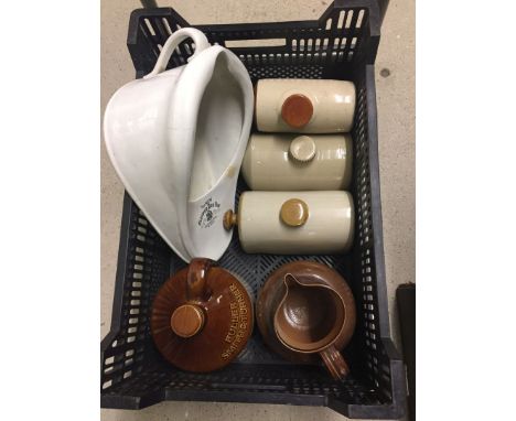 A crate of misc stoneware items comprising: 4 foot warmers, a large stoneware jug and a fullers stoneware flask.