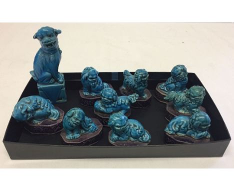 A collection of 10 ceramic temple dogs of blue & purple colouration.