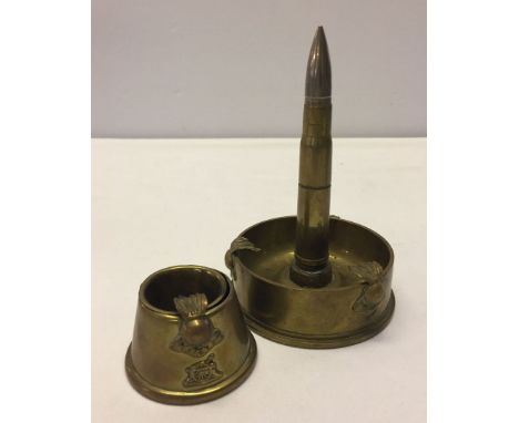 2 pieces of brass trenchart, a small ashtray and an ashtray with lighter, both embossed with Royal Artillery emblem.