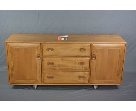 AN ERCOL WINDSOR ELM SIDEBOARD, with three long drawers and two cupboard doors on casters, approximate width 155.5cm x depth 