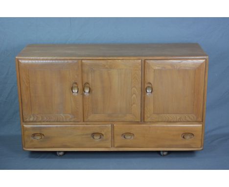 AN ERCOL WINDSOR ELM SIDEBOARD, with three cupboard doors, with central interior drawer and adjustable shelf above two long d