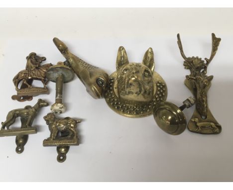 A cast brass door knocker in the form of a dog a stylised dolphin and other door knockers (6)