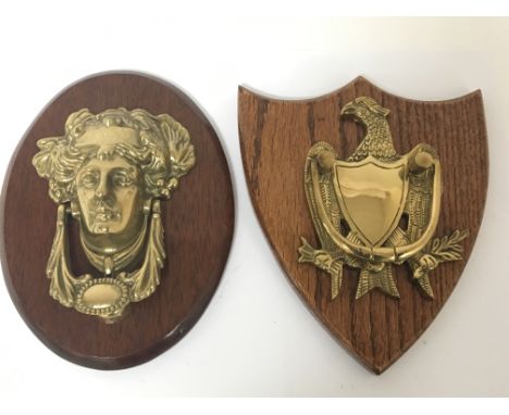 A cast brass American style door knocker in the form of an eagle above a shield and one other classical mask both on polished