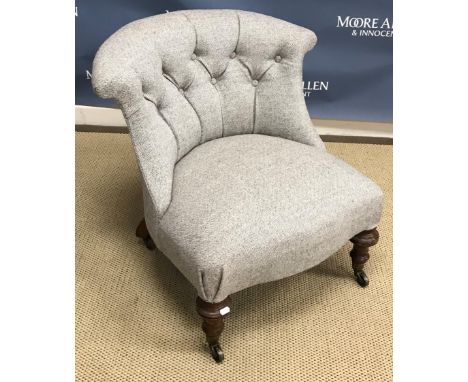 A Victorian low salon chair with button back and brass caps and castors to the front legs inscribed Cope and Collinson patent