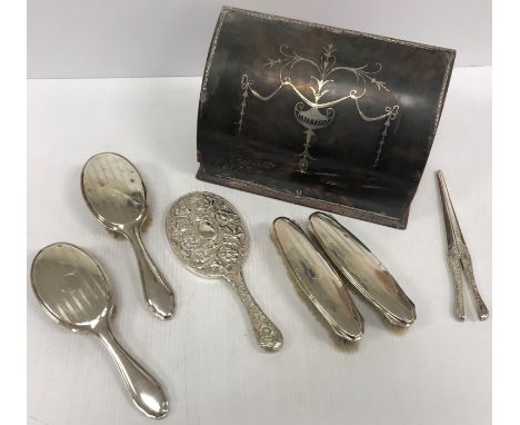 A silver and tortoiseshell mounted desk top stationery box with hinged lid, a silver mounted four piece dressing table brush 