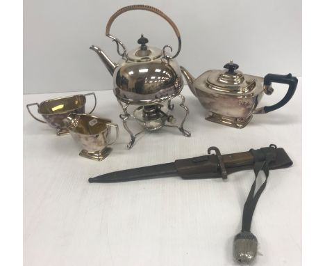 A silver plated three piece tea set with plastic handles and a plated spirit kettle in the Arts &amp; Crafts manner No'd 3473