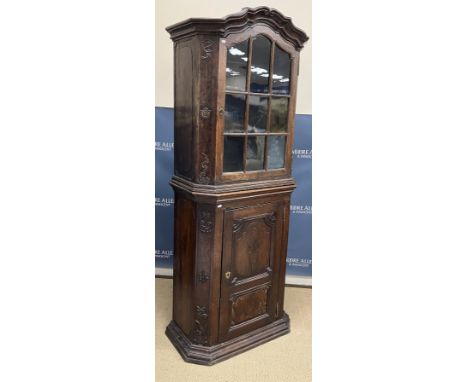 An 18th Century Dutch carved oak side cabinet, the moulded scrollwork decorated cornice over a glazed and barred dome top doo