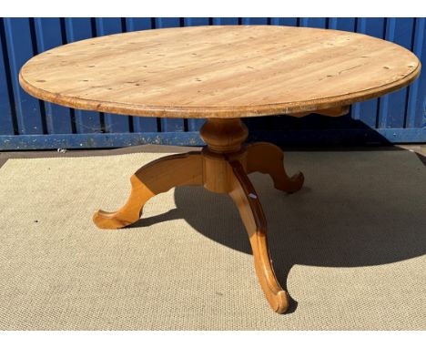 A waxed pine circular kitchen table on centre pedestal to tripod base, 136 cm diameter x 73 cm high, together with a set of s