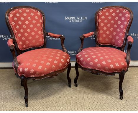 A pair of 19th Century rosewood framed open arm salon armchairs in the Louis XV taste, the shaped moulded backs with upholste