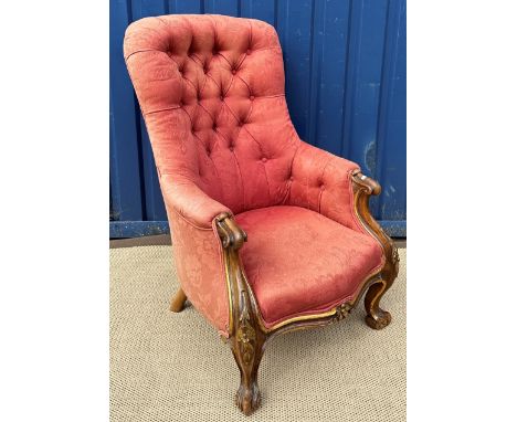 A Victorian carved walnut and gilt decorated three-piece salon suite comprising button back upholstered armchair with show fr