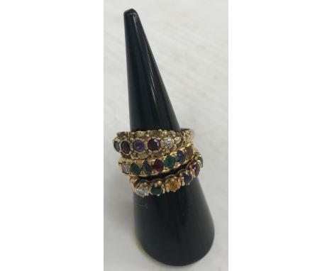 A collection of three 9 carat gold dress rings including a "Dearest" set with diamond, emerald, aquamarine, ruby, emerald, sa