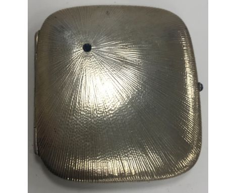 An early 20th Century silver rounded rectangular cigarette box of starburst form, set with off set sapphire to the top with c