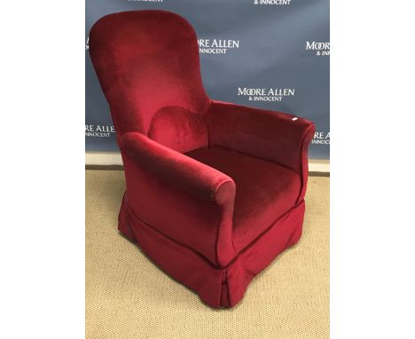A red velvet upholstered scroll arm chair on turned walnut front legs to brass caps and castors, 73 cm wide x 68 cm deep x 95