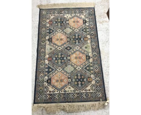 A Persian rug, the central panel set with lozenge shaped medallion on a pale pink ground with stylised foliate and bird decor