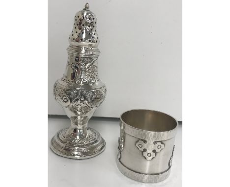 A silver pepper with embossed decoration and loaded base 13.6 cm high and plain napkin ring