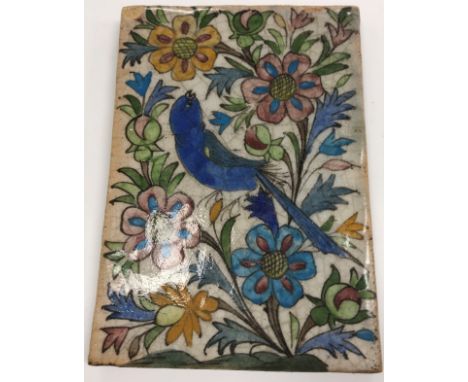 A 19th Century Qajar pottery tile with painted bird and floral decoration, 21 cm x 15 cm