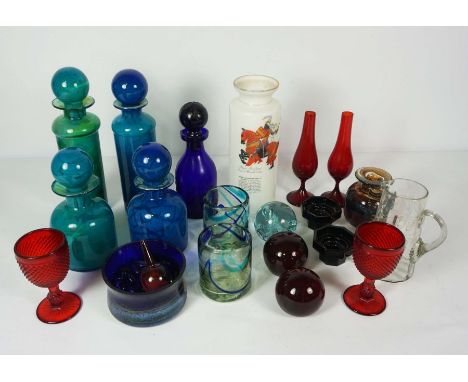 A mixed group of coloured glass, including a pair of ruby glass faceted goblets, assorted blue glass stoppered bottles and pa