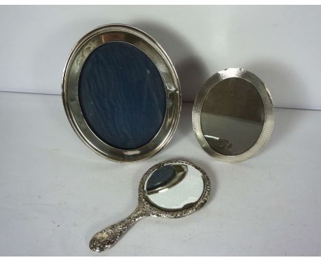 Two silver picture frames, including an oval frame with engine turned decoration, Birmingham 1894, another similar and an sil