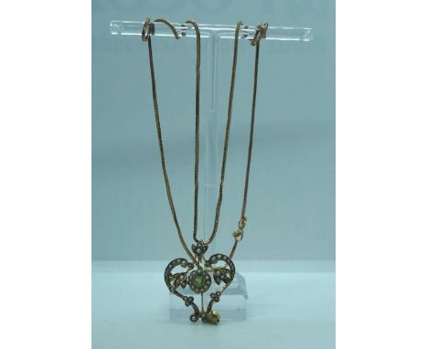A 9 carat gold, peridot, and seed pearl pendant, with double scroll and flower bud setting, on an associated 9k marked gold c