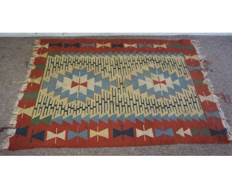 A small Kilim rug, with three lines of octagonal roundels on a light pink red ground, 176cm x 132cm
