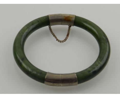 A jade and white metal bangle.