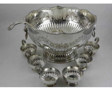 In the 19th century style, a silver plated punch bowl, embossed with flowers and foliage above gardrooned border. together wi