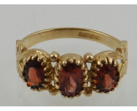 A 9 carat yellow gold three stone garnet ring 