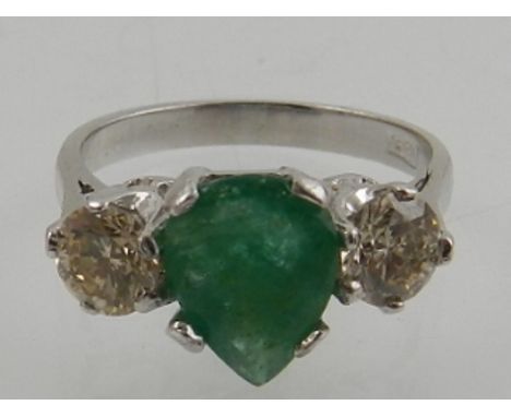 A white metal emerald and diamond dress ring, the shank stamped 18ct.