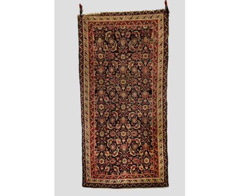 Agra rug, north India, early 20th century, 8ft. x 4ft. 2.44m. x 1.22m. Some areas of wear; hole to upper right side inner pin