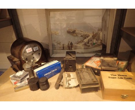 Shelf of collectables including mantle clock, money box, tile press, first aid box etc