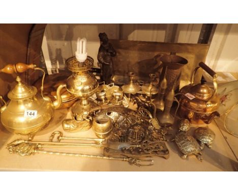 Shelf of assorted brass and copper trivets, converted oil lamp, candlestick holders etc