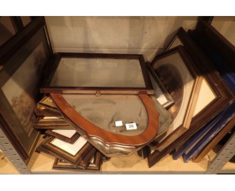 Shelf of assorted framed prints and mirrors and empty frames