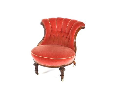 A Victorian button back nursing chair, upholstered in pink dralon and raised on turned tapering front supports, terminating i