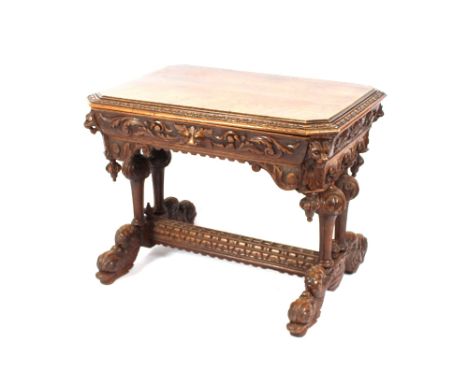 A late Victorian Gothic carved oak side table, fitted with a single drawer, having lion mask decoration, raised on baluster s