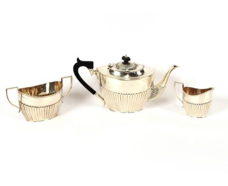 A late Victorian silver three piece tea set, having half fluted body decoration, the teapot with blackwood handle and lift, B