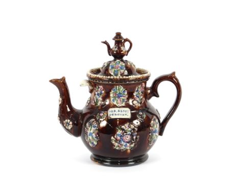 A 19th Century Bargeware teapot, decorated in the traditional manner with clusters of posies on treacle glazed ground, with i