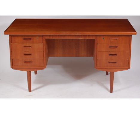 A 1960s Danish teak kneehole writing desk, each pedestal having four upper drawers with integral handles, raised on further t