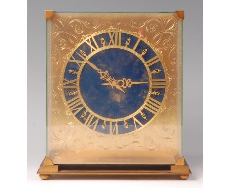 A 1960s/70s gilt brass and glass cased mantel clock by Piaget, having a floating lapis lazuli dial with Roman numerals and pi