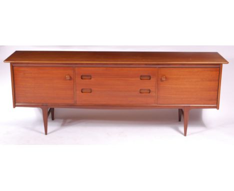 A 1960s Danish long teak sideboard by A. Younger Ltd, having three long central drawers, with integral curved handles, flanke