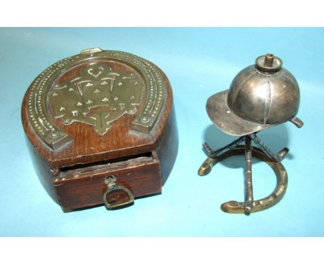 An early-20th century brass and oak cribbage board in the form of a brass horse shoe mounted on an oak block, the card and ma