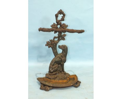 A cast iron stick or umbrella stand in the form of an oak tree branch with a dog seated at its base, with removable half-roun