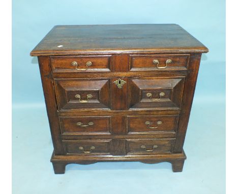 A 17th century oak chest of four harlequin drawers applied with mouldings, on later bracket feet, 95cm wide, 94cm high.