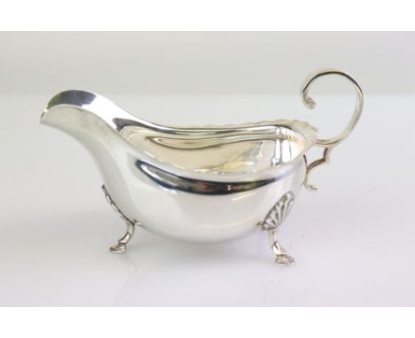 Silver sauce boat raised on three hoof feet, ogee border, scroll handle, makers Harrison Brothers &amp; Howson, London 1912, 