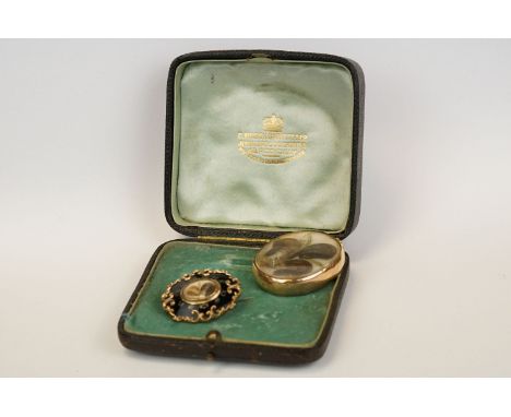 Early 19th century yellow metal pendant, the glazed compartment containing scrolled hair and fine metal ropework, yellow meta